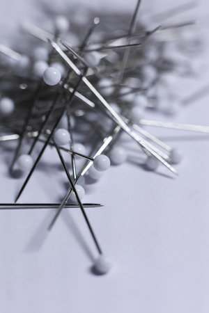 Needles and pins for sewing on a white background. Selective focus.の写真素材
