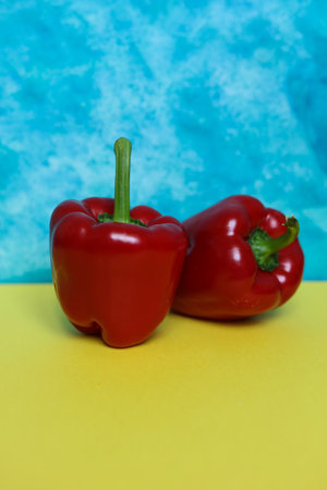 Two red bell peppers on a colorful background. Close up.の写真素材