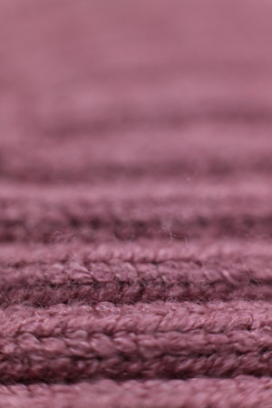 Close up of knitted pink fabric texture background. Macro shot.