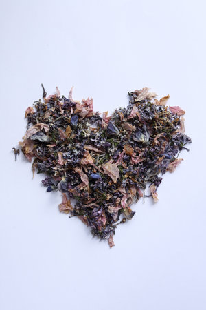 A heart of dried herbal tea on a white background, top view