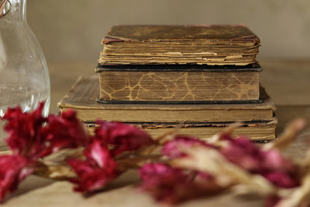 Old books and dried flowers on wooden table. Selective focus.の写真素材