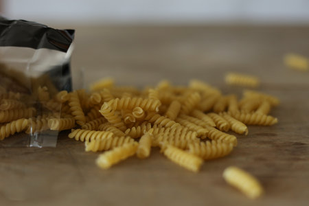 Fusilli italian pasta on wooden background. Selective focus.の写真素材