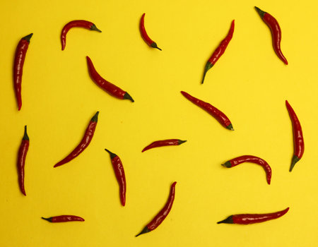 Red hot chili peppers on yellow background. Flat lay, top view