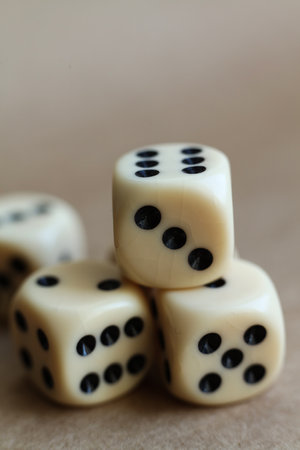 Dice on beige background with shallow depth of field and copy spaceの写真素材