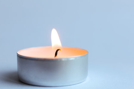 Candle on light background, close-up, space for textの写真素材
