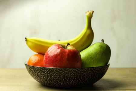 Still life of fresh fruits in a bowl on wooden table, selective focusの写真素材