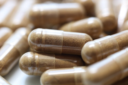 Close-up of a pile of brown pills on a white plate