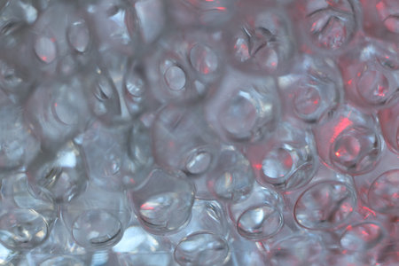 macro photo of hydrogel balls in red lightの写真素材
