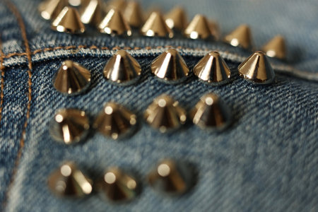 Jeans close-up. Details of a denim jacket with silver spikes. Selective focus.の写真素材