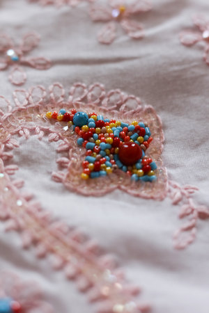 Beautiful embroidery on a pink fabric. Close-up.の写真素材