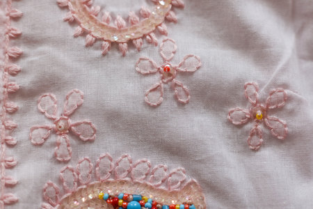 Beautiful embroidery on a pink fabric. Close-up.の写真素材