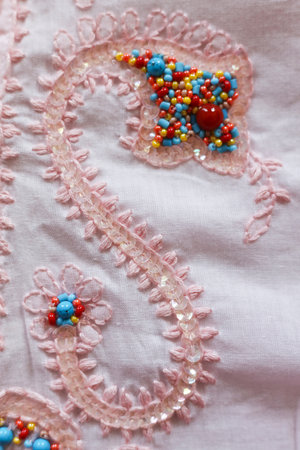 Beautiful embroidery on a pink fabric. Close-up.の写真素材