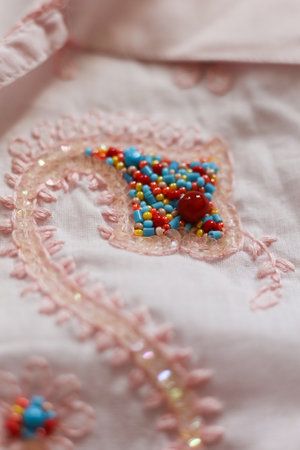 Beautiful embroidery on a pink fabric. Close-up.の写真素材