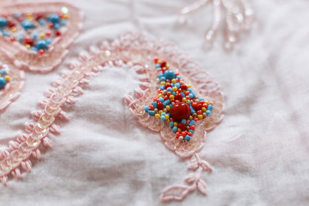 Beautiful embroidery on a pink fabric. Close-up.