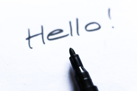 Hello text written on white paper with a black felt-tip penの写真素材