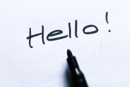 Hello text written on white paper with a black felt-tip penの写真素材