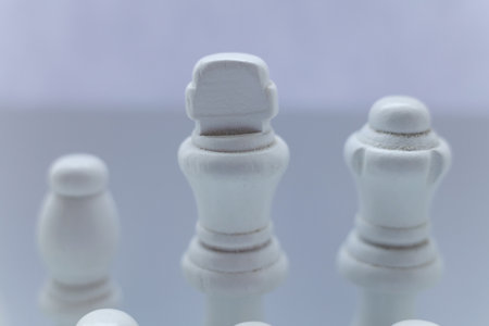 Macro photograph of a white chess king and queen standing together on a mint green and white chessboard. Minimalistic pastel composition symbolizing partnershipの写真素材