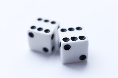 Two white dice with black dots on a white background. Close-up.の写真素材