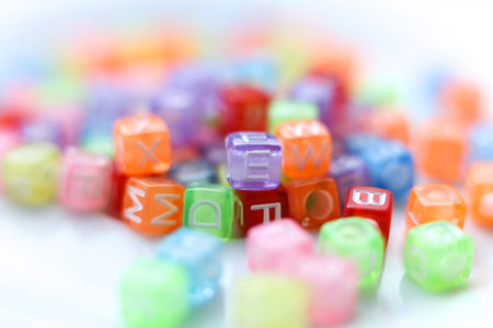 Close-up macro photograph of vibrant, translucent alphabet beads in assorted colors. Soft selective focus and bright playful tonesの写真素材