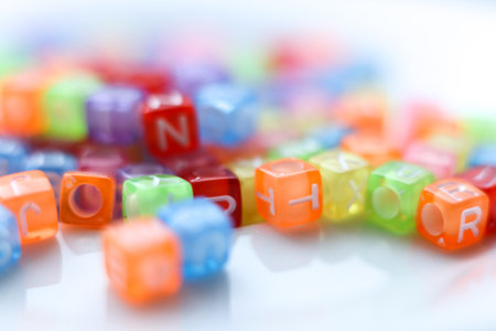Close-up macro photograph of vibrant, translucent alphabet beads in assorted colors. Soft selective focus and bright playful tonesの写真素材
