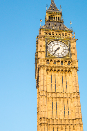 Big Ben tower in London behind fences with blue skyの写真素材