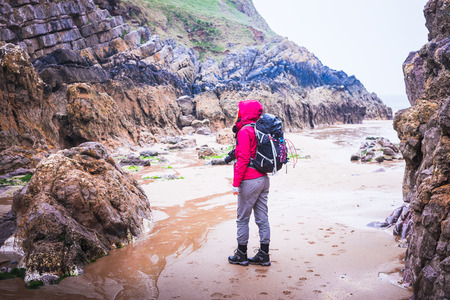 Woman Standing On The Rocky Beach In Rhossili Bay, Walesh Coast Path, Walesの写真素材