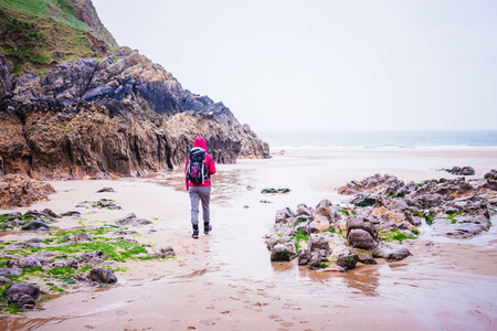Woman Walking On The Rocky Beach In Rhossili Bay, Walesh Coast Path, Wales