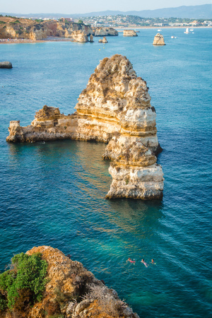 People swimming in the sea on the shoreline of Lagos coasts, Algarve, Portugal.の写真素材