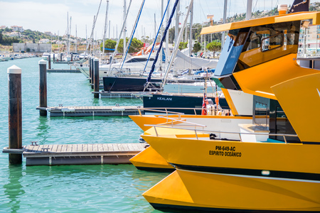 Yellow dolphin watching coastline cruise catamaran tied in the bay of Marina de Albufeira, Albufeira Algarve, Portugal.のeditorial素材
