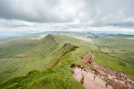 People hiking on the hillside of Pan Y Fan in Brecon Beacons, Wales.の写真素材