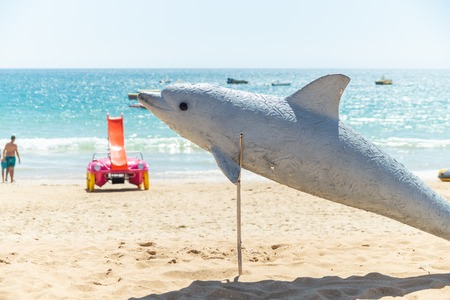 Dolphin sculpture indicating dolphin watch opportunity on the Albufeira beach, Algarve, Portugalの写真素材
