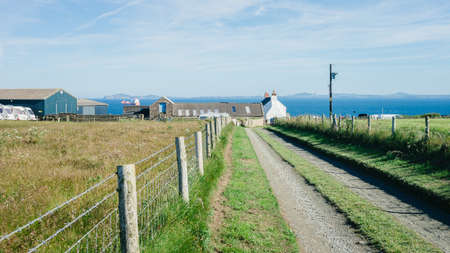 Martin's Haven, Wales - July 1, 2017: Dirt road leading to West Hook Farm Camping with St. Brides Bay in the background - Pembrokeshire West Wales UK.のeditorial素材