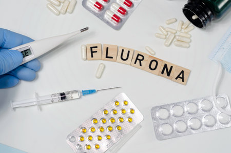 The word FLUOR is made of wooden cubes, next to pills and a thermometer.