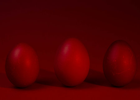 Three red Easter eggs on a red background. Close-up.の写真素材