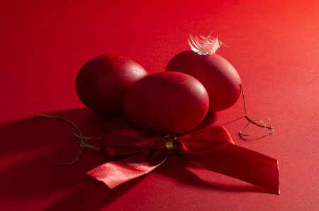 Easter eggs with red ribbon on red background. Happy Easter.の写真素材
