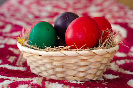 Easter eggs in a basket on a red background. Selective focusの写真素材