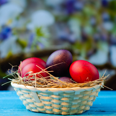 Easter eggs in a basket on a blue wooden background. tinting. selective focusの写真素材