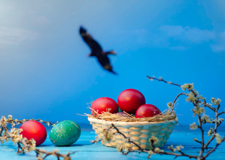 Easter eggs in a basket and a bird on a blue backgroundの写真素材
