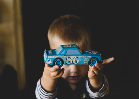 Little boy playing with a toy car in the living room at homeの写真素材
