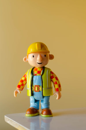 Plasticine construction worker with safety helmet and safety vest on yellow backgroundの写真素材