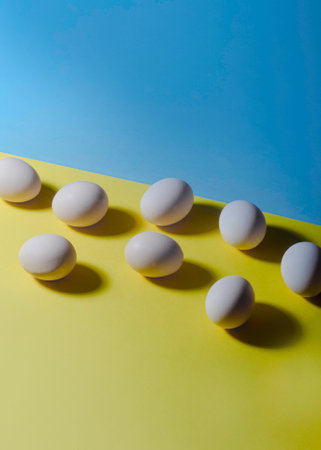 White eggs on a yellow and blue background. Place for text.の写真素材