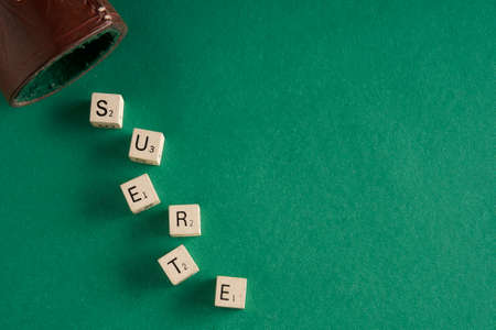 dice on green table forming the word lucky in spanish luckの写真素材