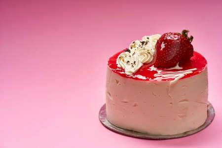 individual cheese cake with strawberry on a pink background copy space