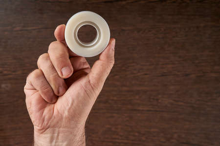 man's hand holding adhesive tapes