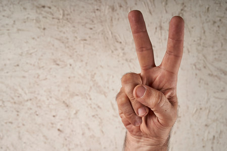 man's hand making a V with two of his fingers