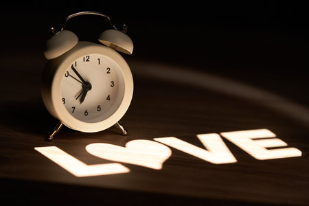 retro style alarm clock, illuminated with the word Love on the nightstandの写真素材
