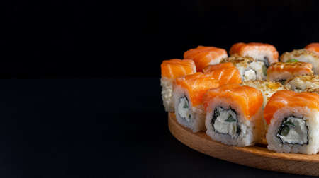 Philadelphia roll with salmon, avocado, cream cheese on black background. Japanese food. Sushi menuの写真素材