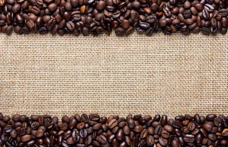 Border frame of coffee beans on the old burlapの写真素材