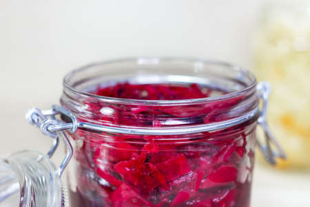 Fermented red cabbage lies in a glass jar. Sauerkraut with spices. Copy space.の写真素材