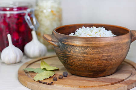 Sauerkraut in a clay bowl on a wooden rustic background. Fermented foodの写真素材